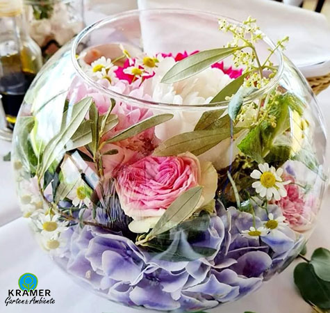 Tischdeko im Glas mit rosa Blüten